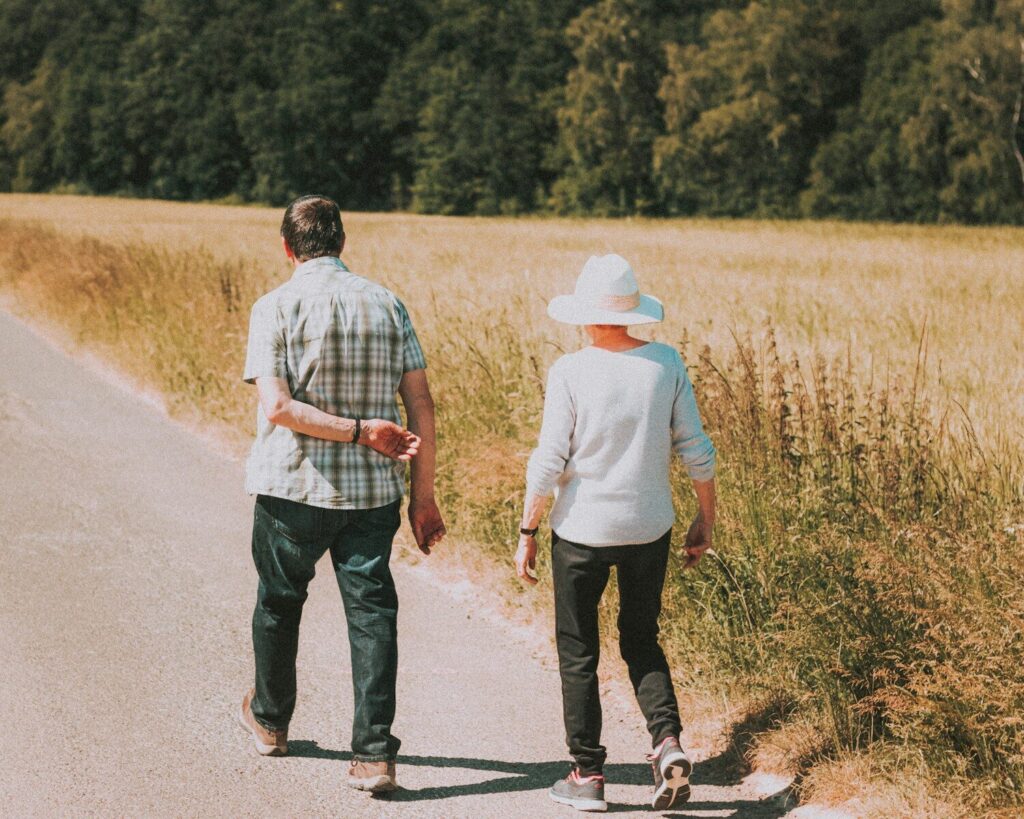 man and woman holding hands while walking on road during daytime